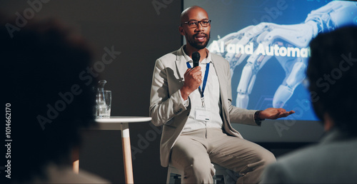 Black man, stage and microphone at conference for technically and AI discussion as public speaker. Male person, screen and presentation for global networking, seminar and summit in auditorium