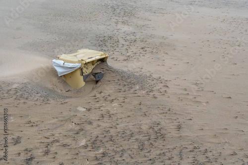 yellow garbage cans sunk in the sand, north sea, netherlands photo