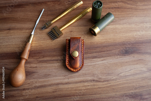 Fotografie a handcrafted leather knife sheath with a brass button clasp, various leatherwor