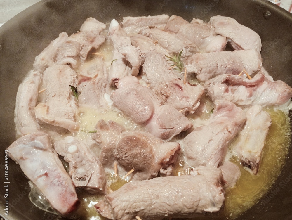 mixed pork meat cooked in a pan with rosemary and sage, butter, oil and salt