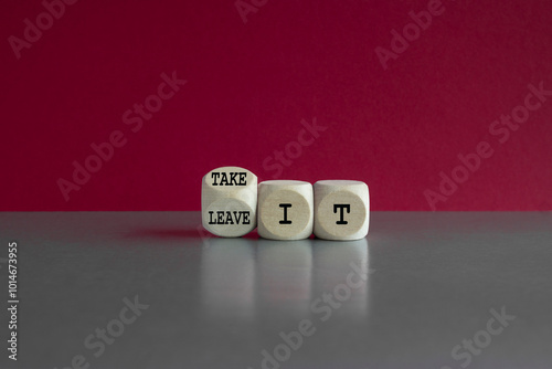 Take or leave it symbol. Turned a wooden cube and changes words Leave it to Take it. Beautiful gray table pink background. Business and take or leave it concept.