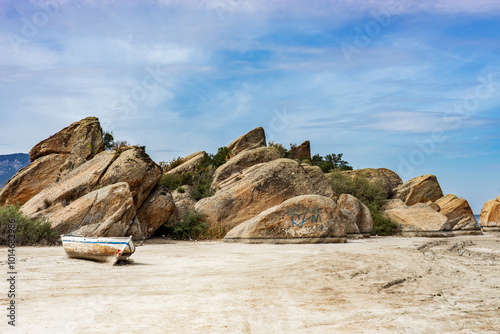 The Wreckage of a Local Fishing Boat Is the Rocks on the Coast of the Lake Bafa, Turkey photo