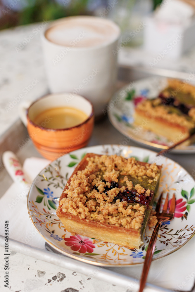 dessert and coffee for two. nut cake with pieces of pistachios and coffee on the table in an open-air cafe. dessert and coffee for two. nut cake with pieces of pistachios and coffee on the table in an open-air cafe.