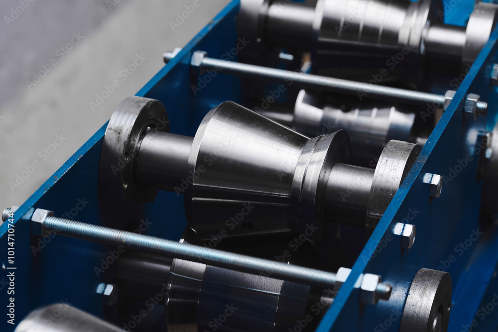 Rolled metal, metal processing and manufacturing of metal fence, close-up of metal rolling equipment at the factory Rolled metal, metal processing and manufacturing of metal fence, close-up of metal rolling equipment at the factory