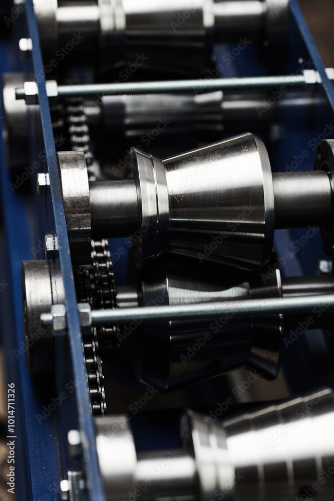 Rolled metal, metal processing and manufacturing of metal fence, close-up of metal rolling equipment at the factory Rolled metal, metal processing and manufacturing of metal fence, close-up of metal rolling equipment at the factory