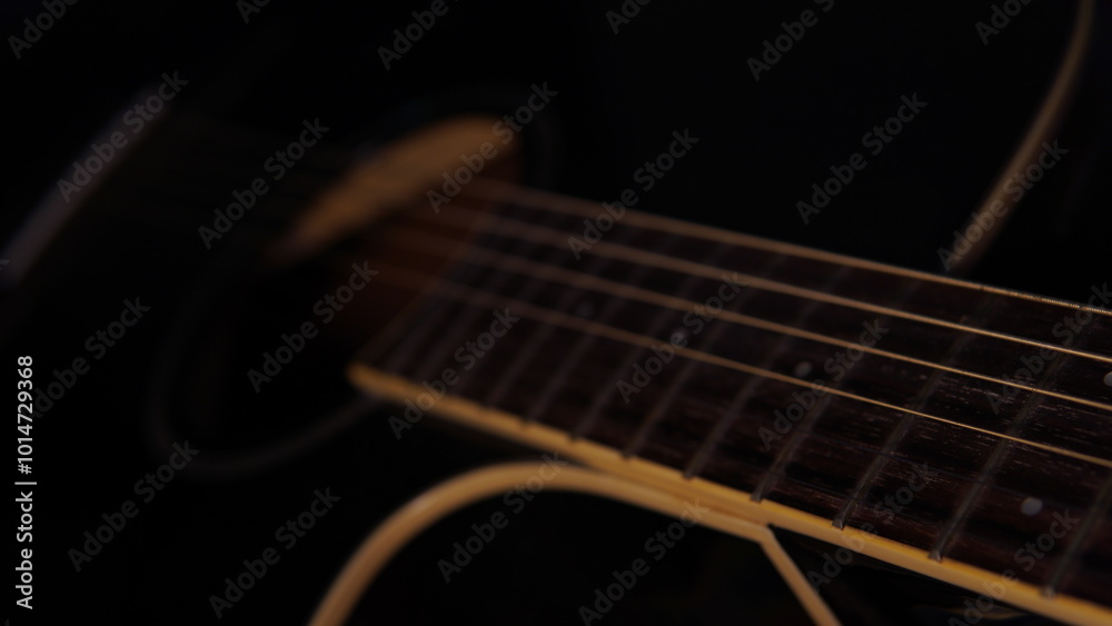 Fototapeta premium guitar background. selective focus. guitar on a dark background with a hint of warm light. guitar strings and fret board. acoustic guitar