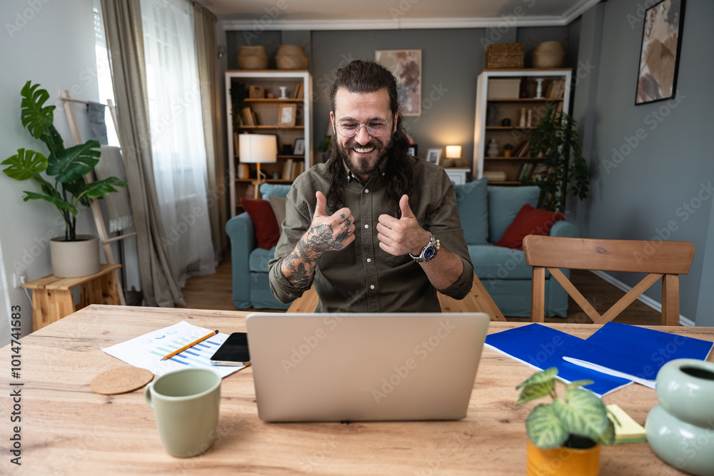 Joyful freelance businessman sitting at desk looking at computer screen talking with client make video call. Online home worker received great news read email feels happy getting reward or promotion. Joyful freelance businessman sitting at desk looking at computer screen talking with client make video call. Online home worker received great news read email feels happy getting reward or promotion.