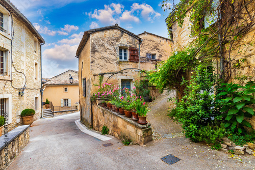 Charming street in quaint Menerbes village with colorful buildings and vibrant flowers. Village of Menerbes (Most Beautiful Village in France) in the Luberon mountains, France, Luberon, Vaucluse.