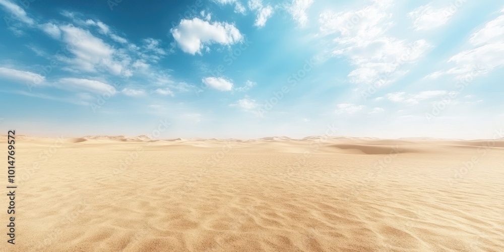 Naklejka premium Expansive desert landscape under a bright blue sky with fluffy clouds and gentle sand dunes, showcasing nature's tranquility.