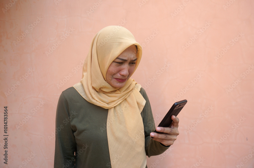 Young Asian Woman Looking At Smartphone With Sad Expression