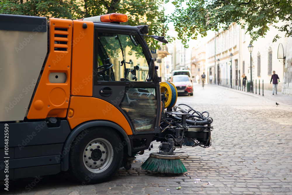 Municipal car for cleaning and brush roads or sidewalks outdoors. Steel Broom of Road Sweeper Car Machine. The concept of cleaning city streets, business, industry.
