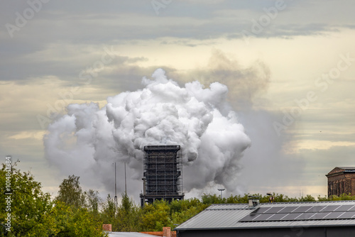 Smoke and steam released from the old factory chimney photo