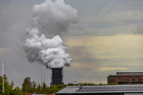 Smoke and steam released from the old factory chimney photo