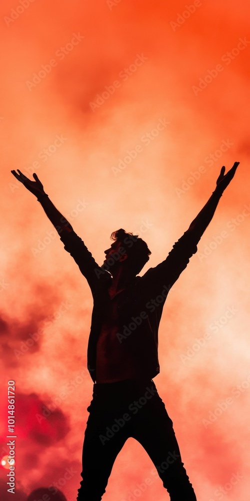 A silhouette of a man raising his arms in a fiery celebration, surrounded by dramatic smoke and bright orange lighting in the background. A silhouette of a man raising his arms in a fiery celebration, surrounded by dramatic smoke and bright orange lighting in the background.