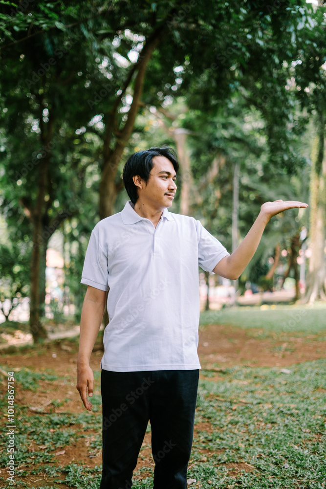 Southeast Asian man showing something with his right hand, highlighting an object or idea. Southeast Asian man showing something with his right hand, highlighting an object or idea.