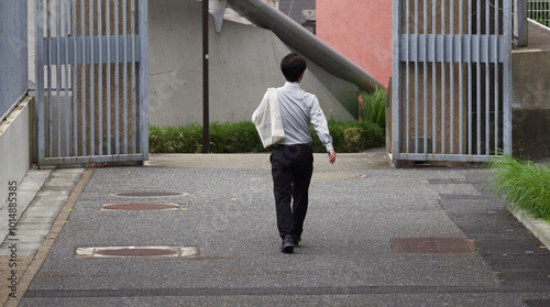 秋の早稲田大学校内の道で歩く一人の男性教授の姿