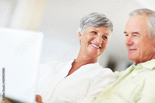 Senior couple, laptop and home for online blog, surfing social media and internet for communication. Elderly people, relax and together for bonding in living room, reading funny ebook and streaming