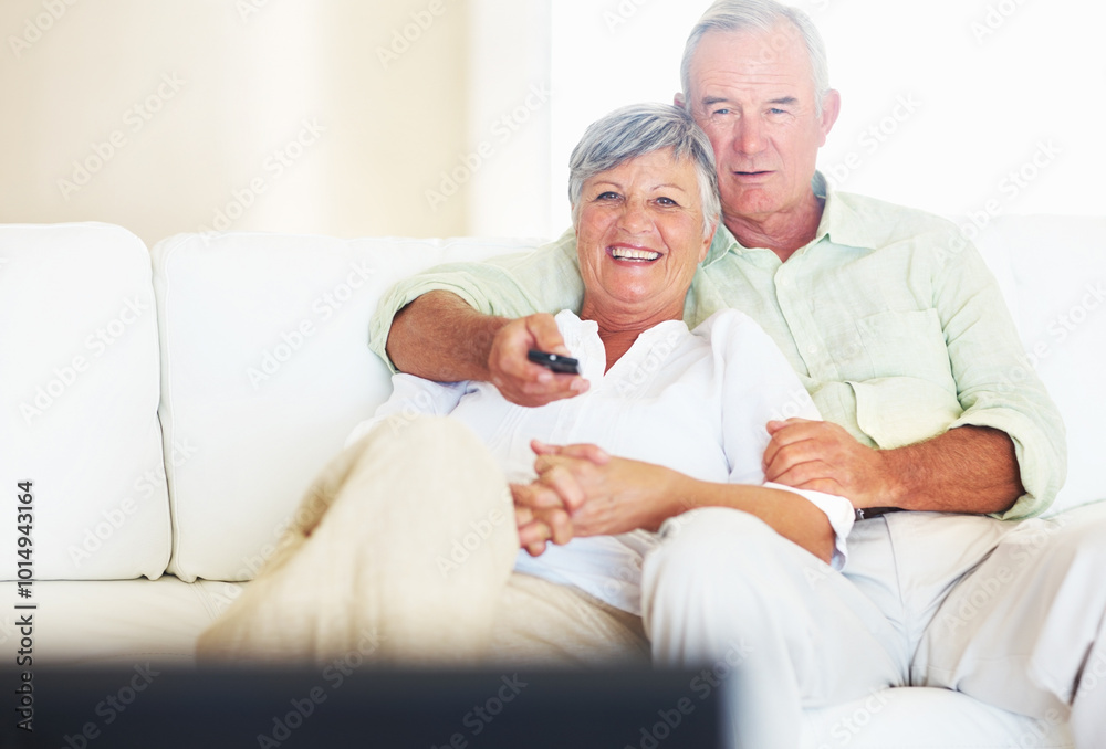 Happy, mature couple or watching tv with remote on sofa for movie, shows or online streaming at home. Elderly, man or woman with smile for cuddle, hug or entertainment by television together at house Happy, mature couple or watching tv with remote on sofa for movie, shows or online streaming at home. Elderly, man or woman with smile for cuddle, hug or entertainment by television together at house