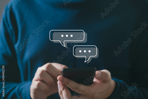 Person using smartphone with chat icons appearing above. Concept of digital communication, text messaging in modern lifestyle.