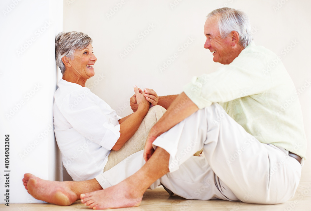 Obraz premium Senior couple, happy and holding hands for love, relax and bonding in house with smile, care or support. Man, woman and romance in apartment for relationship, marriage and communication with trust