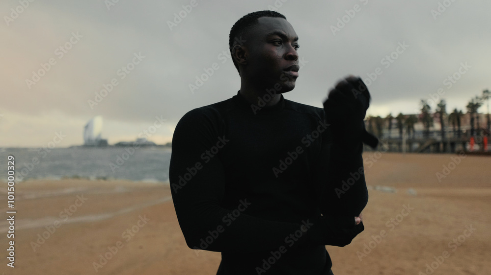 Fit guy does street workout, stretching and warming up, looks out to sea on a cloudy day, sport motivation and sporty lifestyle Fit guy does street workout, stretching and warming up, looks out to sea on a cloudy day, sport motivation and sporty lifestyle