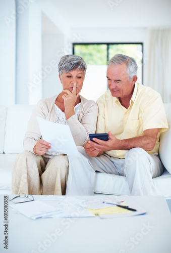 Senior, couple and documents with calculator in home with budget planning, asset management and discussion. Elderly, people and thinking on sofa with paperwork for pension funding, bills and banking