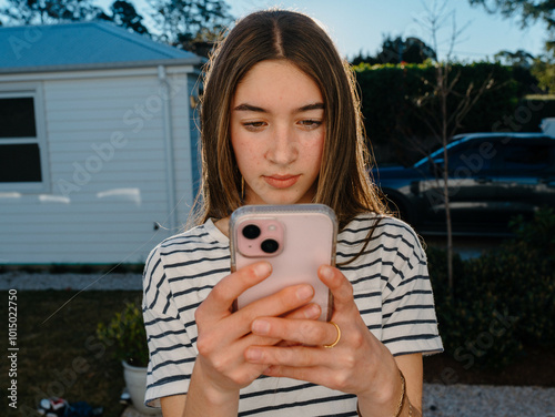Young teenage girl holding a mobile device.