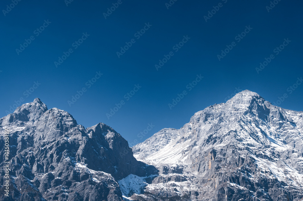 Fototapeta premium Snow-capped mountains under a clear blue sky
