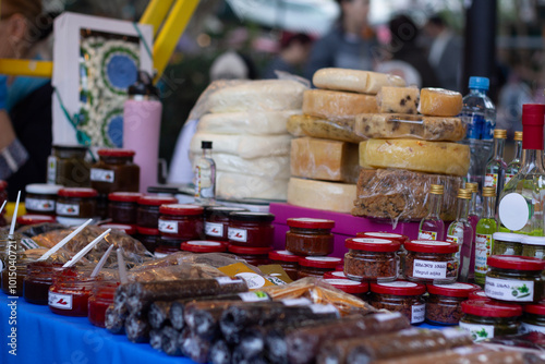 Cheese counter in street store. Table with spices in jars, alcohol, drink, glass bottle. Autumn harvest festival Tbilisoba. Holiday fair. Tbilisi. Georgia. Translation from Georgian: megruli adjika photo