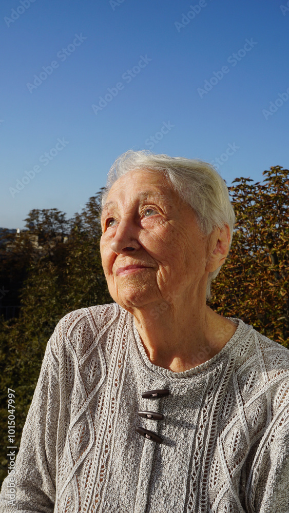 Portrait of sad senior woman posing in autumn park