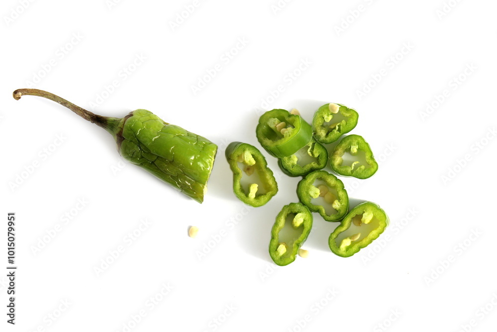 Sliced green hot pepper lies on a white background. Sliced green hot pepper lies on a white background.