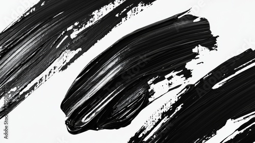 Abstract black paint strokes on a white background create a striking visual contrast and dynamic design.