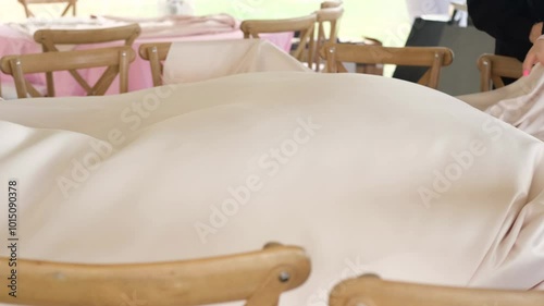 Event planner spreading a luxurious tablecloth over a table in smooth slow motion, showcasing elegance and attention to detail