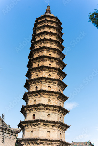 Yongzuo Temple, also known as the Twin Pagodas Temple, Taiyuan, Shanxi, China, Asia, with blue sky, white clouds and sunlight illuminating the tall towers photo