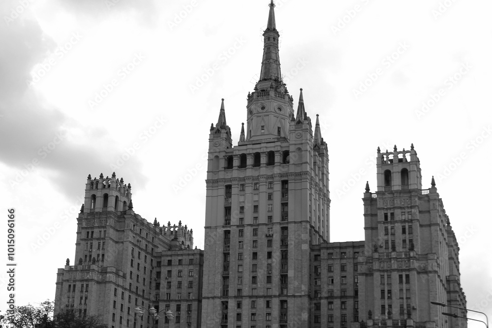 A tall building with a spire stands against a cloudy sky. A tall building with a spire stands against a cloudy sky.