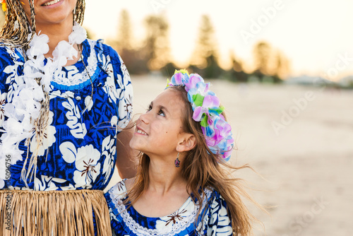 Torres Strait Islander girl looking up at mother in traditional dancer floral garland