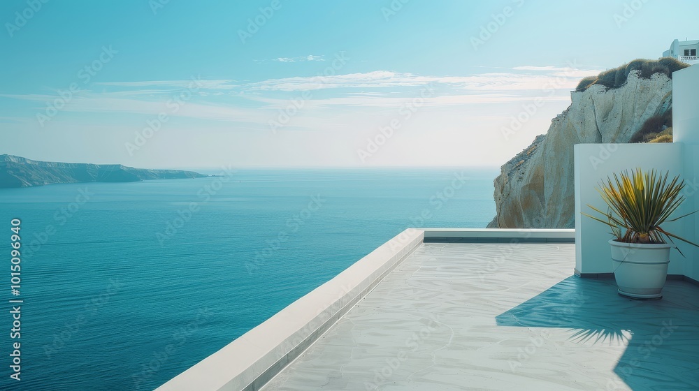 Fototapeta premium Terrace with sea view in Santorini style, featuring white walls and concrete floor, overlooking the cliff and ocean, with a distant island in clear midday sun.