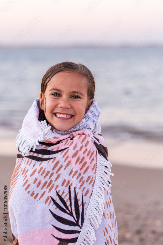 Happy First Nations Australian girl wrapped in a warm towel after swimming at the beach Happy First Nations Australian girl wrapped in a warm towel after swimming at the beach