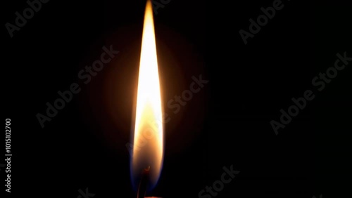 A realistic, flickering candle flame gently moving against the black background, casting a warm glow