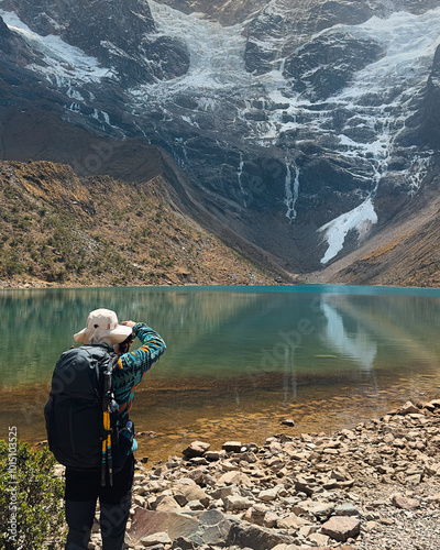 man surrounded by high mountains taking photos.