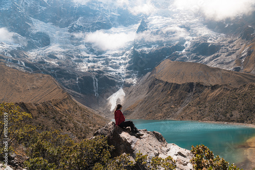 Young woman admiring the views in the humantay lake, Peru, after a long and thought hike. Showing success and glory. Copy space.