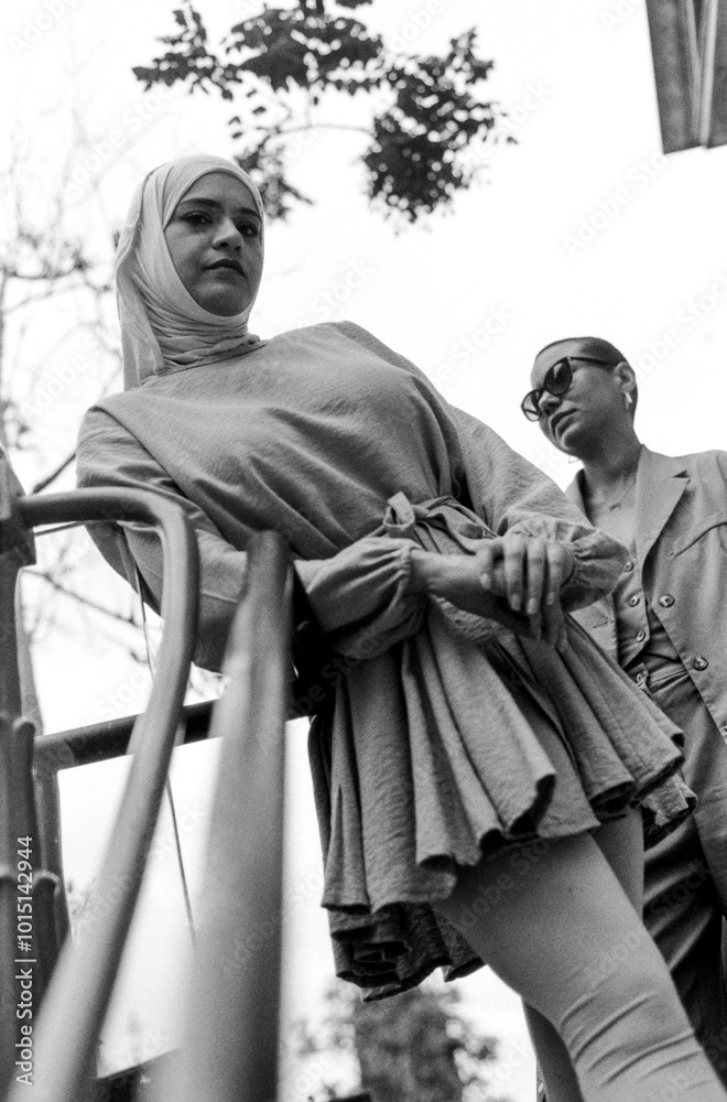 Naklejka premium Urban portrait of female friends posing leaning on a banister.