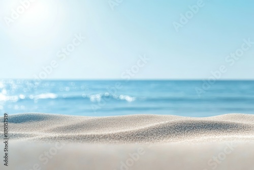 Warm beach sand in focus with the calm sea and cloudy sky in the distance