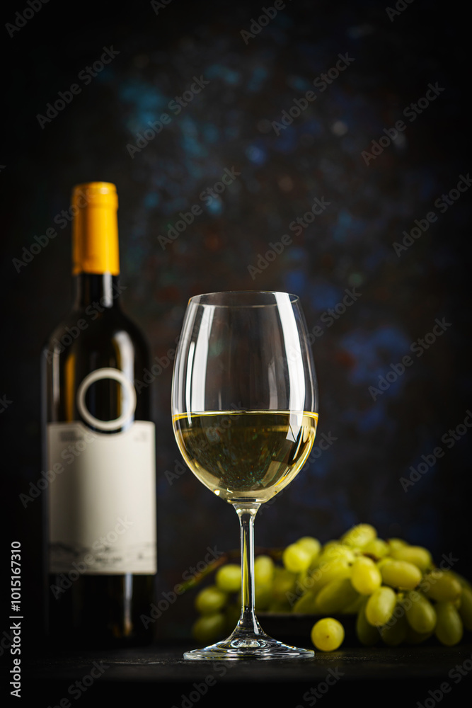 A dark, elegant still life of white wine in a glass with wine bottles and fresh grapes in the background. Perfect for wine-themed compositions A dark, elegant still life of white wine in a glass with wine bottles and fresh grapes in the background. Perfect for wine-themed compositions
