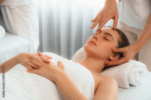 Caucasian woman enjoying relaxing anti-stress head massage and pampering facial beauty skin recreation leisure in dayspa modern light ambient at luxury resort or hotel spa salon. Quiescent