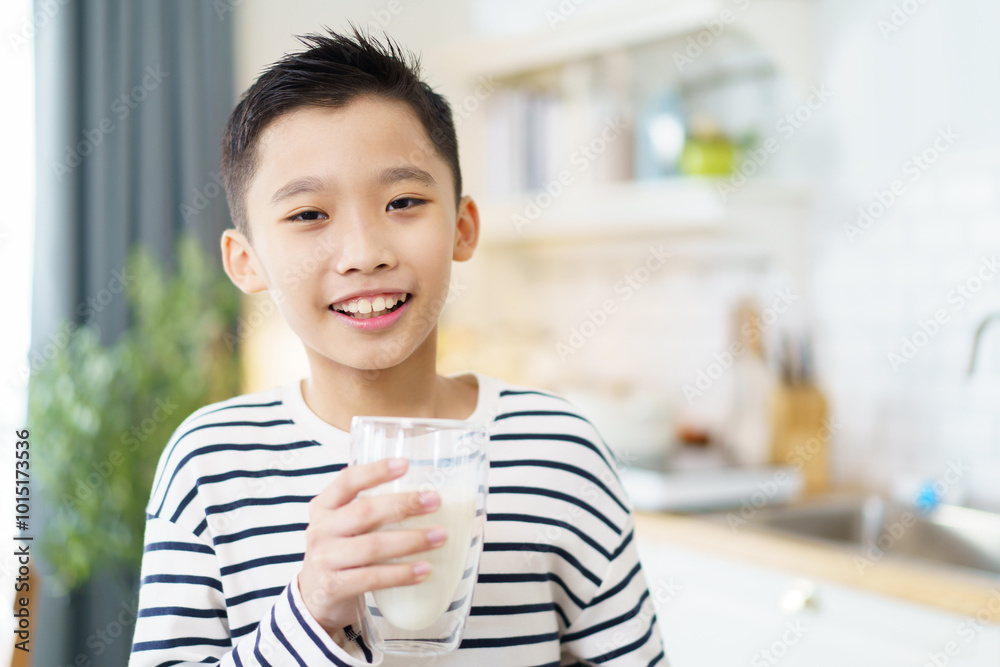 Asian delightful boy is drinking a fresh milk in morning.