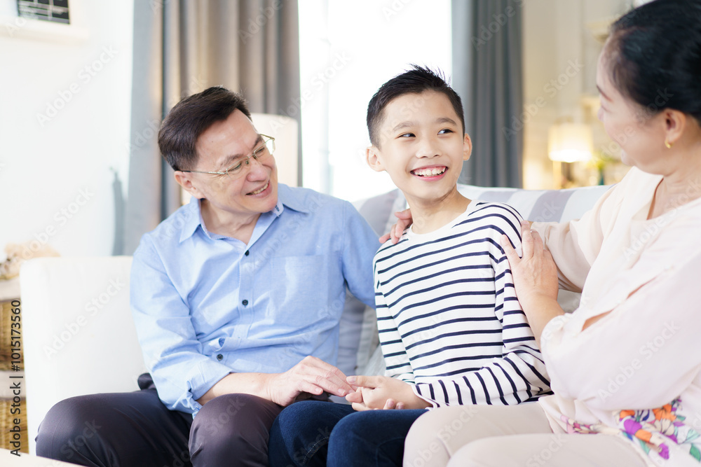 Asian family with father, mother, and son staying in living room together. Asian family with father, mother, and son staying in living room together.