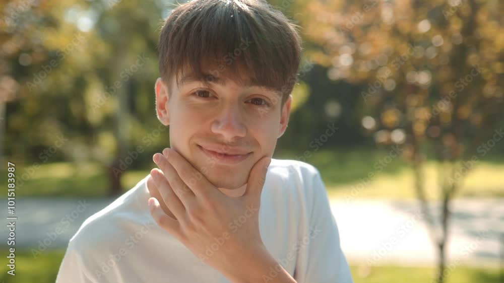 Joyful adolescent in white t-shirt smiling in natural sunlight Joyful adolescent in white t-shirt smiling in natural sunlight