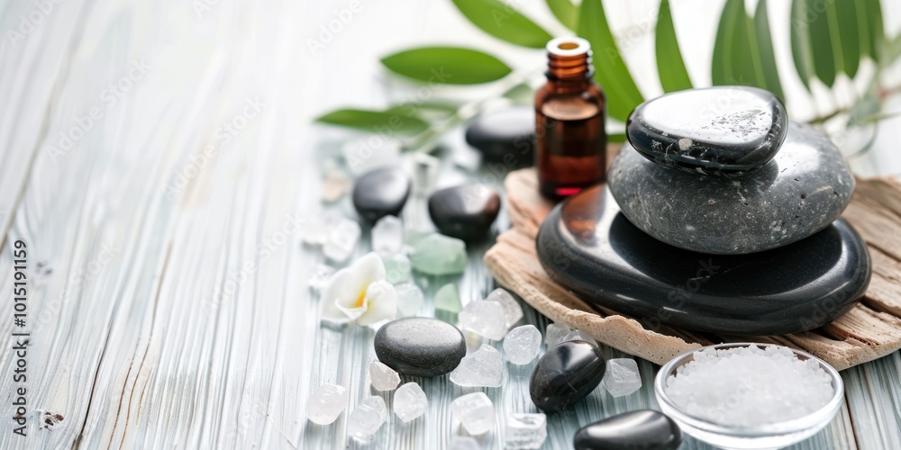 Spa and wellness concept with black stones, essential oils, and sea salt on a light wooden surface. Spa and wellness concept with black stones, essential oils, and sea salt on a light wooden surface.