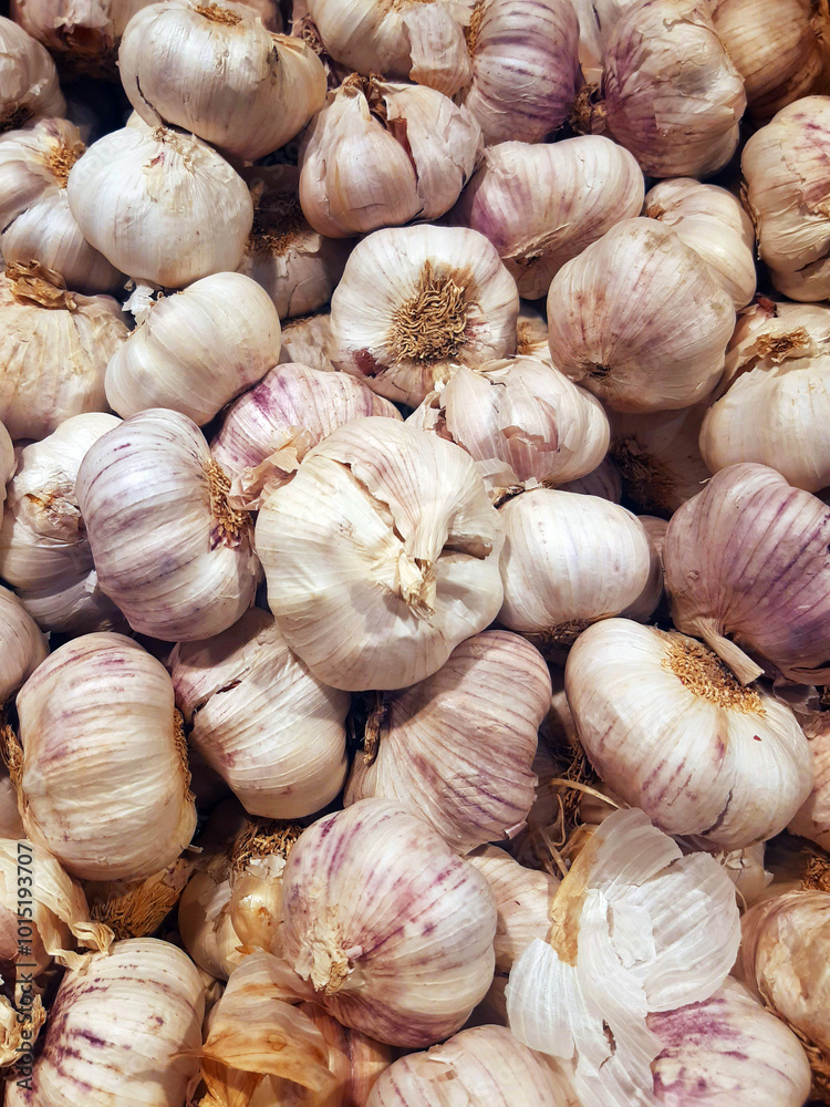 Fresh garlic in the market. Close up of raw natural garlic in bulk. Bunch of organic and ecological heads of garlic. Vegetables background. Sustainable and healthy food. Fresh garlic in the market. Close up of raw natural garlic in bulk. Bunch of organic and ecological heads of garlic. Vegetables background. Sustainable and healthy food.